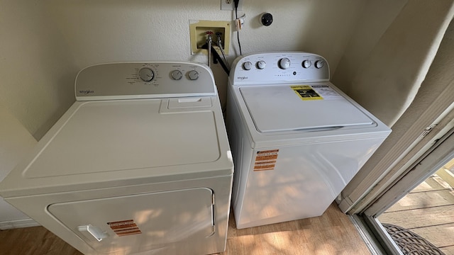 washroom with laundry area, independent washer and dryer, and wood finished floors