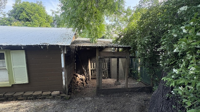 view of outbuilding featuring fence and an outdoor structure