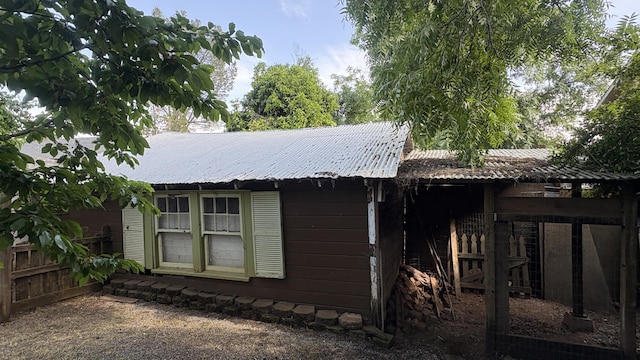 exterior space with fence and metal roof