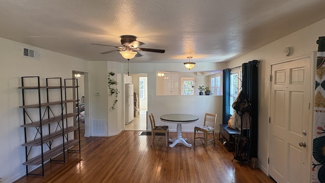 foyer entrance featuring visible vents, a ceiling fan, and wood finished floors
