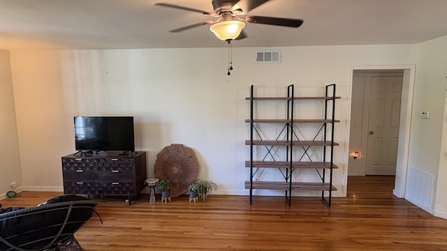 interior space with baseboards, wood finished floors, and visible vents