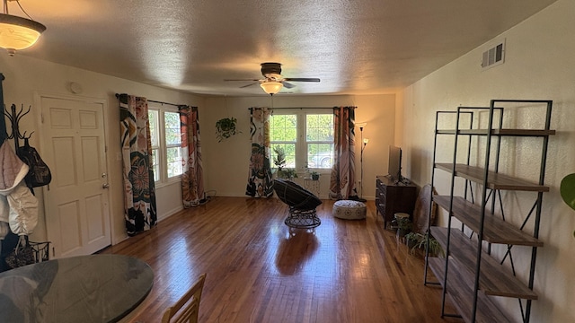 interior space with visible vents, a ceiling fan, a textured ceiling, and wood finished floors