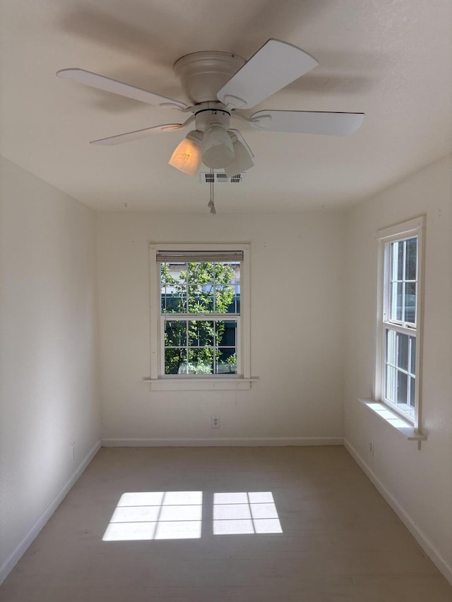 empty room featuring baseboards, visible vents, and ceiling fan