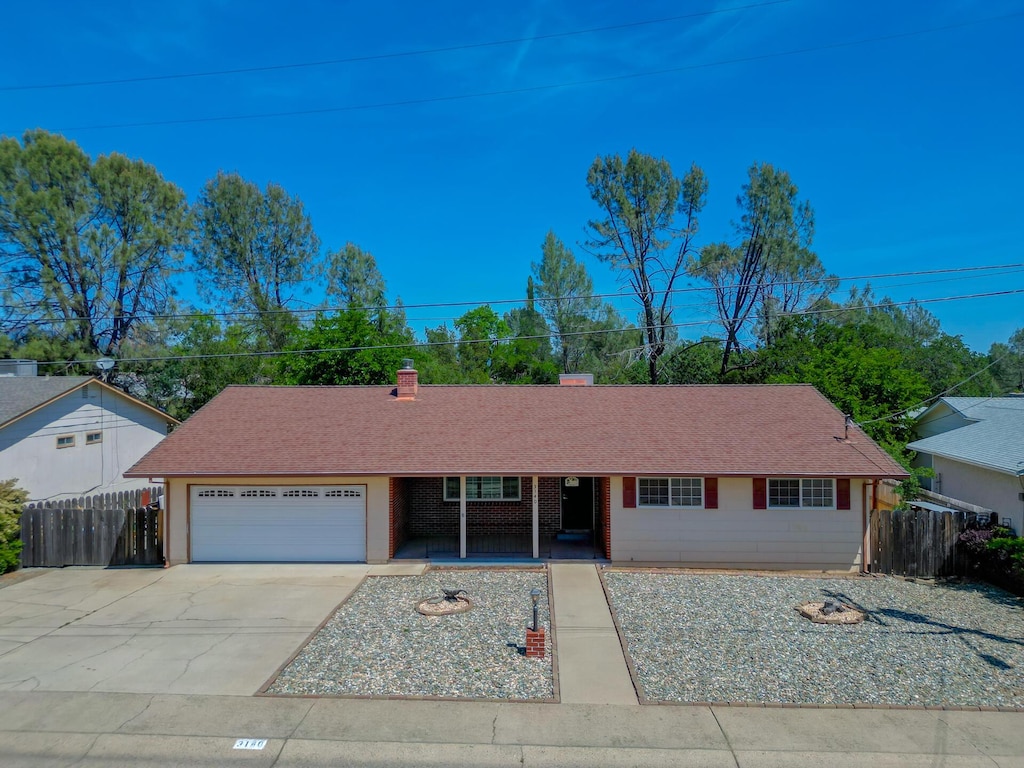 3140 Winding Way, Redding, CA 96003 - ranch-style house featuring a garage, fence, concrete driveway, and a porch