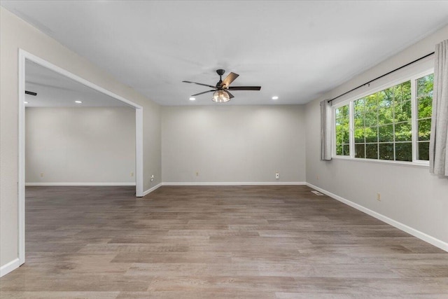 unfurnished room with a ceiling fan, baseboards, light wood finished floors, and recessed lighting