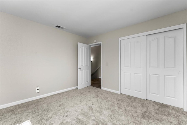 unfurnished bedroom with carpet floors, baseboards, visible vents, and a closet