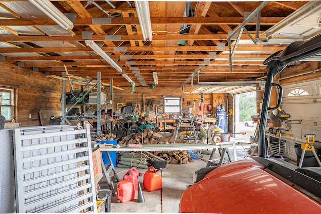 garage with a workshop area and wooden walls