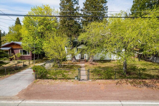 979 Lassen Ln, Mount Shasta, CA 96067 - view of property hidden behind natural elements with a gate, a fenced front yard, and concrete driveway