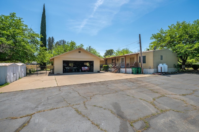 view of front facade with covered porch, an outdoor structure, a garage, and fence