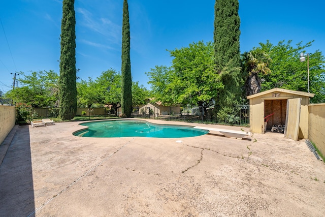 view of pool featuring a patio area, an outdoor structure, a storage unit, a fenced backyard, and a fenced in pool