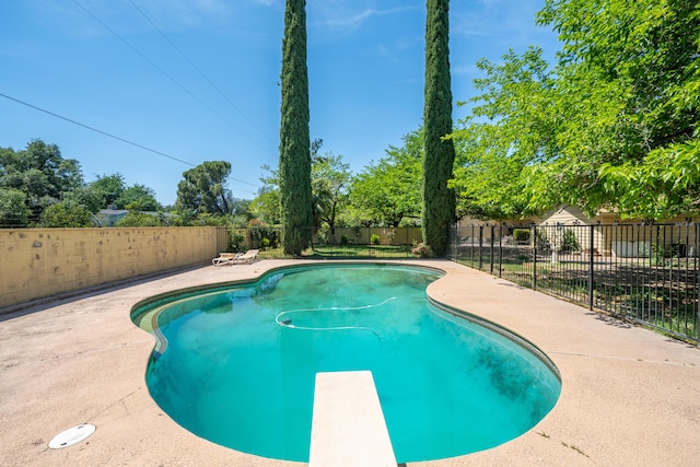 view of pool with a patio, a diving board, a fenced in pool, and a fenced backyard