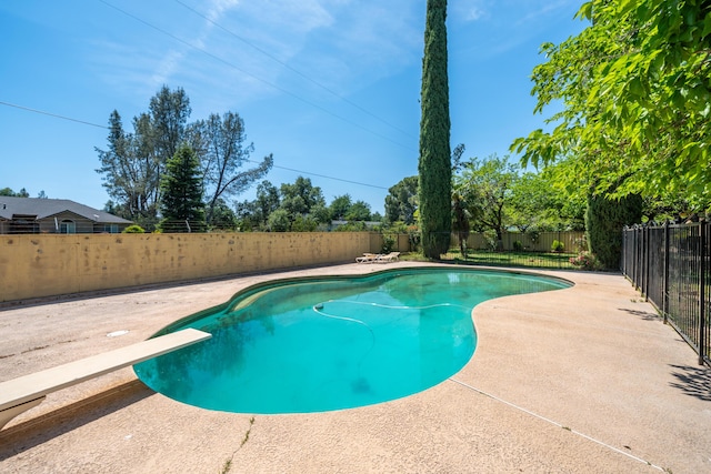view of swimming pool with a patio, a diving board, a fenced in pool, and a fenced backyard