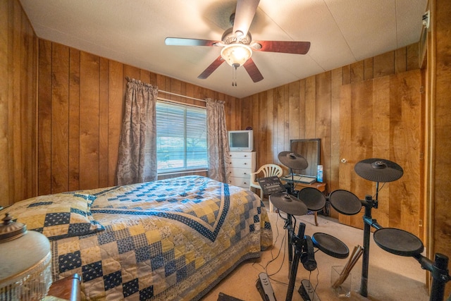 carpeted bedroom with ceiling fan and wooden walls