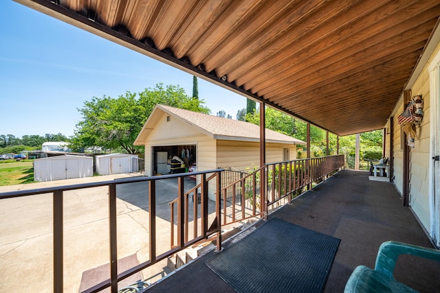 view of patio with a storage unit, a garage, and an outbuilding