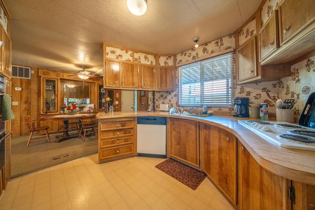 kitchen with light floors, white appliances, light countertops, and brown cabinets