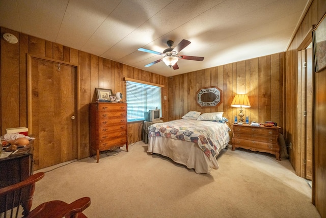 carpeted bedroom with wood walls and a ceiling fan