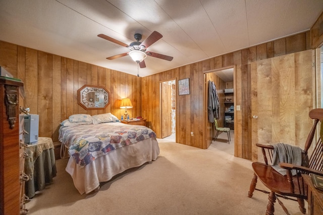 bedroom featuring carpet, wooden walls, and a ceiling fan