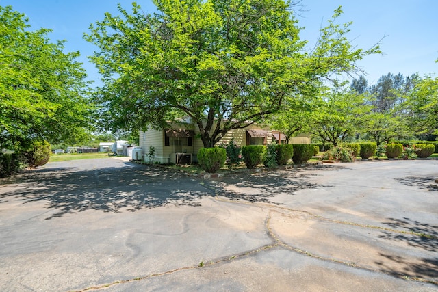 view of side of property with central AC unit and driveway