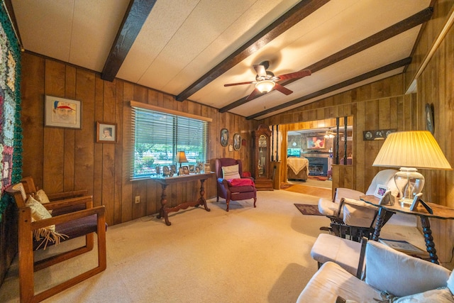 living area with carpet, a ceiling fan, wooden walls, and lofted ceiling with beams