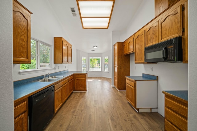 14556 Ryan Ln, Red Bluff, CA 96080 - kitchen with visible vents, brown cabinetry, wood finished floors, a sink, and black appliances