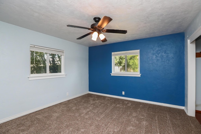 carpeted empty room featuring a textured ceiling, ceiling fan, and baseboards