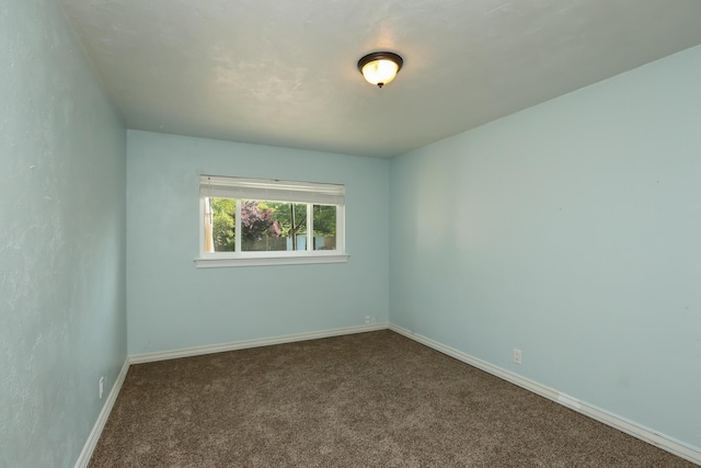 carpeted empty room featuring baseboards