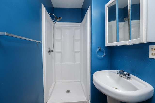 bathroom with a sink and a stall shower