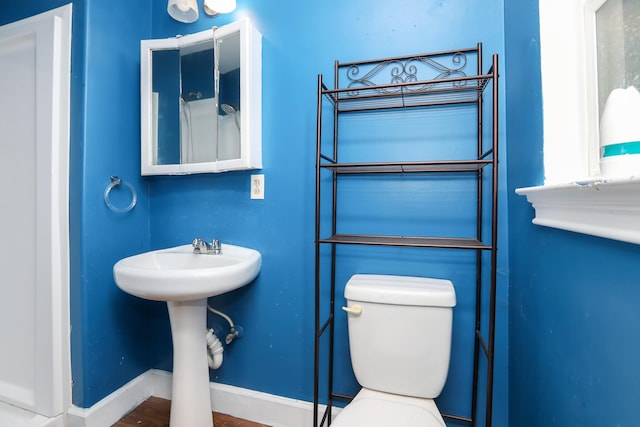 bathroom with toilet, baseboards, and a sink