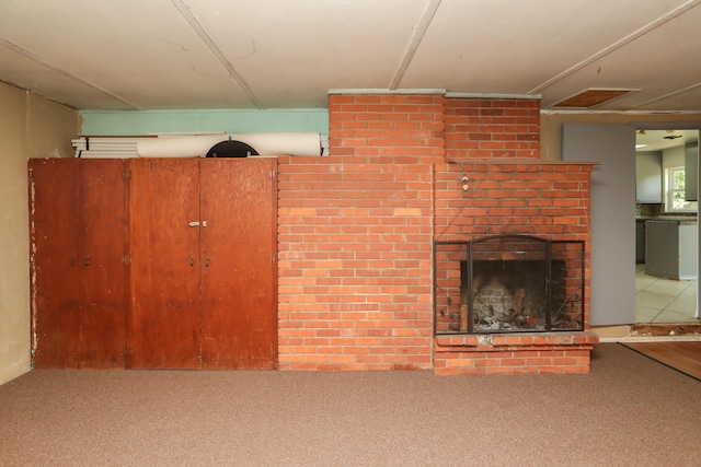 unfurnished living room featuring carpet floors and a brick fireplace