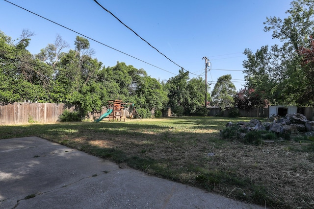 view of yard with fence and a playground