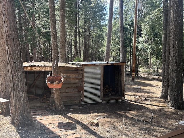 view of outbuilding with an outdoor structure and a wooded view