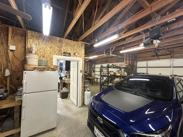 garage with freestanding refrigerator and a garage door opener