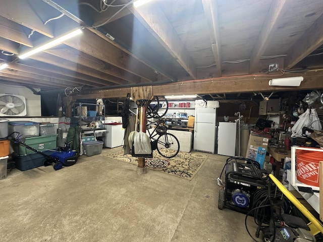 unfinished basement with freestanding refrigerator and refrigerator