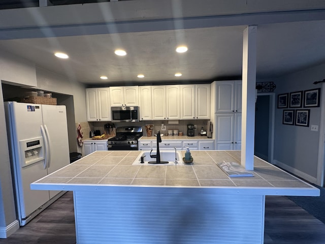 kitchen with recessed lighting, white cabinets, a sink, dark wood finished floors, and appliances with stainless steel finishes