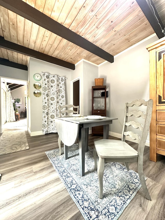 dining room featuring wooden ceiling, baseboards, beam ceiling, and wood finished floors