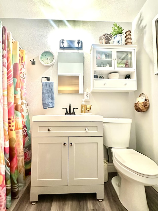 full bathroom with vanity, toilet, and wood finished floors