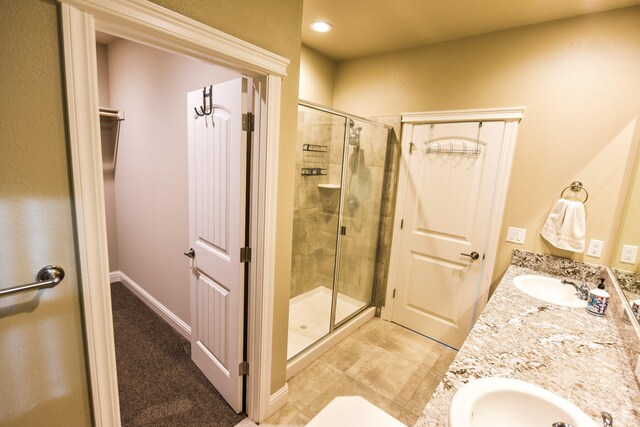2876 Calaveras Ct, Redding, CA 96002 - full bathroom featuring a stall shower, double vanity, baseboards, and a closet