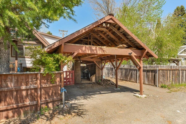 view of parking featuring fence and a carport