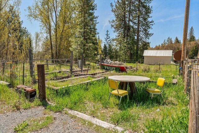 view of yard with an outdoor structure, fence, and a shed