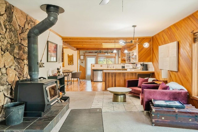 living room with a wood stove and wood walls