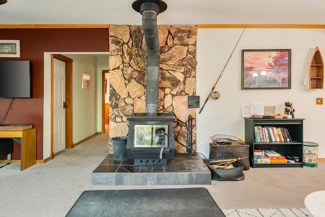 living area featuring carpet flooring, baseboards, and a wood stove