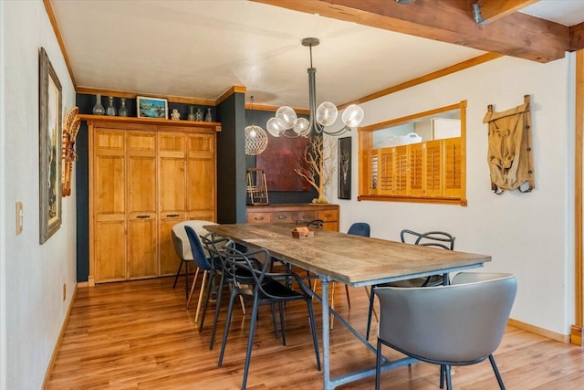 dining area featuring a chandelier, light wood-style flooring, crown molding, and baseboards