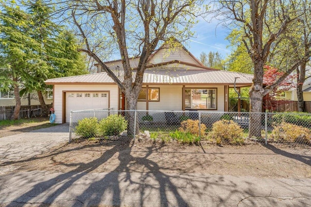 view of front of house featuring fence, metal roof, covered porch, an attached garage, and aphalt driveway