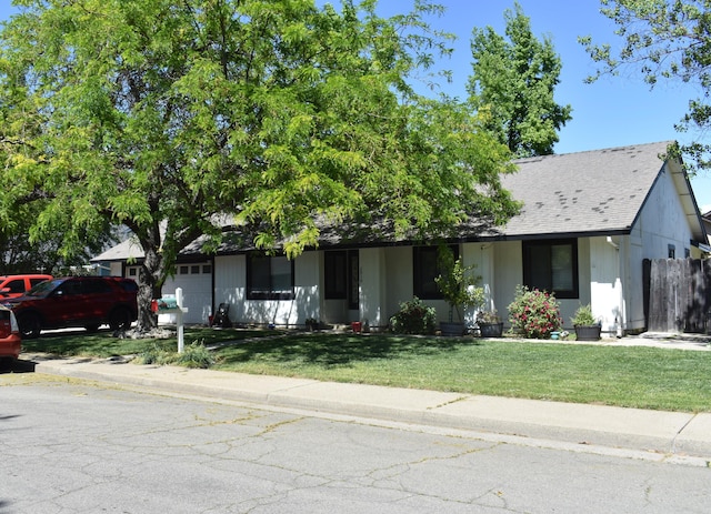 ranch-style house with an attached garage and a front lawn