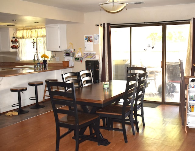 dining space featuring a wealth of natural light, visible vents, and dark wood-style flooring