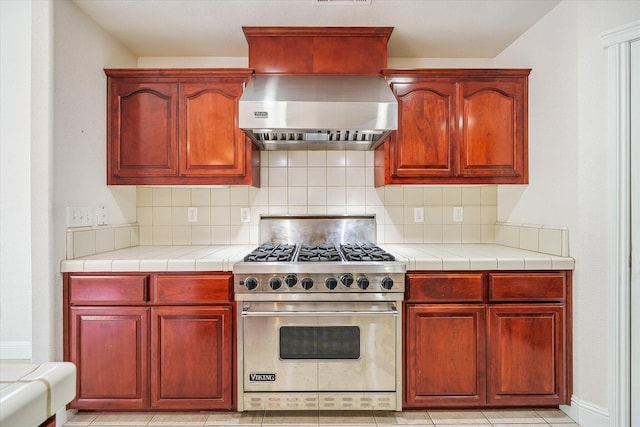 4217 Pendleton Ct, Shasta Lake, CA 96019 - kitchen featuring premium stove, dark brown cabinets, decorative backsplash, and extractor fan