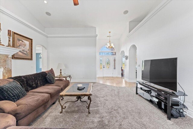 living area with tile patterned floors, a fireplace, an inviting chandelier, arched walkways, and baseboards
