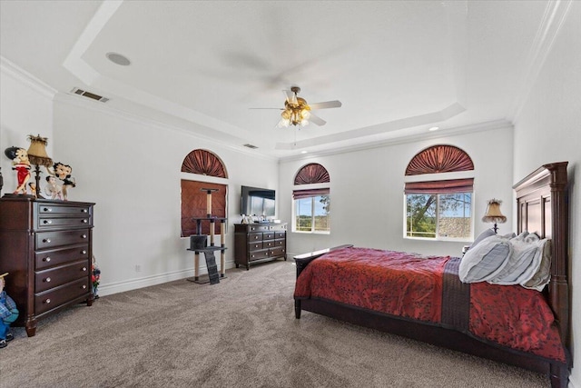 bedroom with carpet floors, visible vents, a raised ceiling, ceiling fan, and ornamental molding