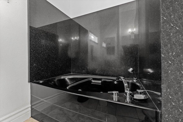bathroom with walk in shower and a tub with marble appearance