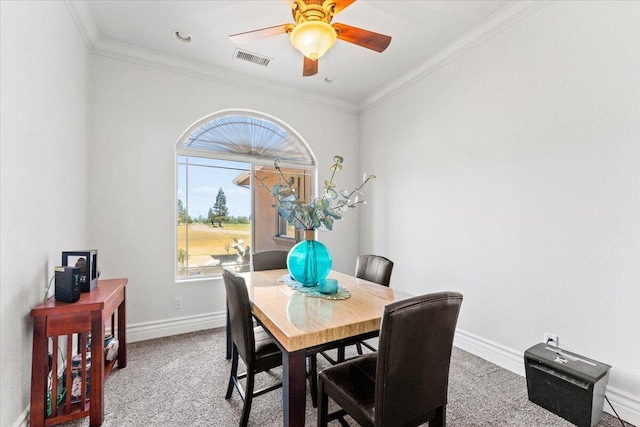 dining space with crown molding, baseboards, ceiling fan, and carpet floors